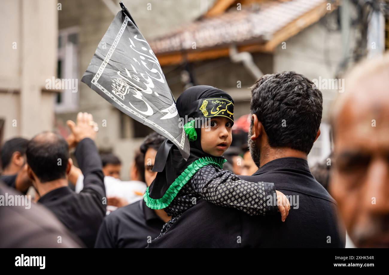 Srinagar, India. 14th July, 2024. A Kashmiri Shia Muslim girl looks on ...