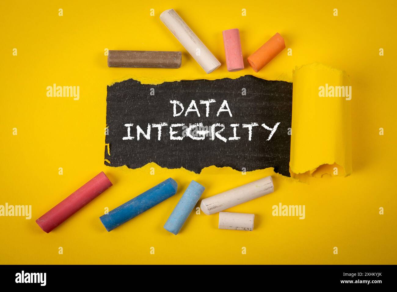 Data integrity. Text under torn yellow paper on a blackboard. Stock Photo