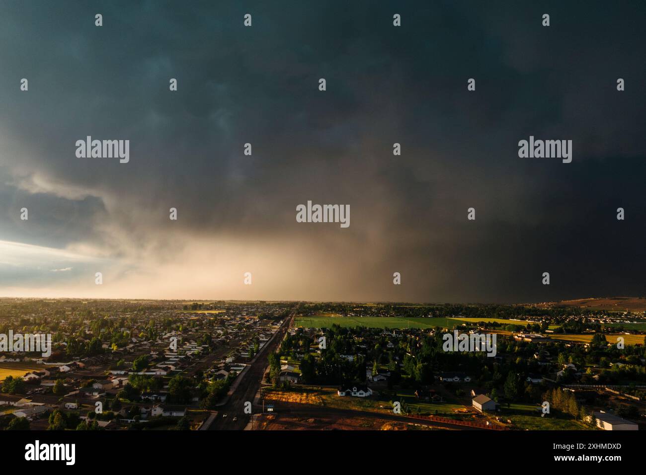 Dramatic storm clouds sweep across the sky at sunset. Stock Photo