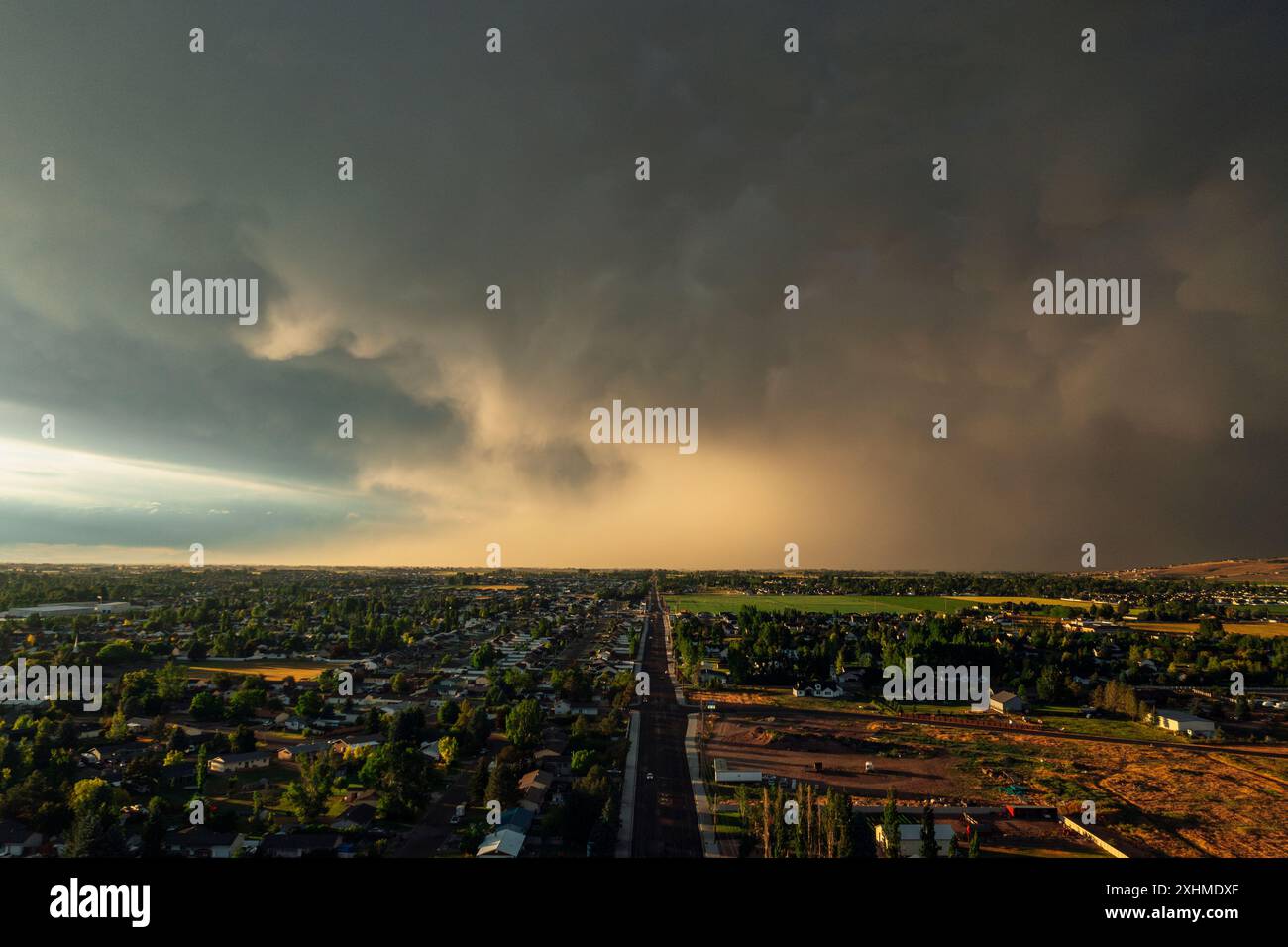 Dramatic storm clouds sweep across the sky at sunset. Stock Photo