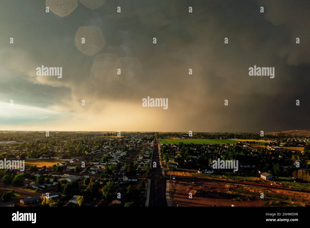 Dramatic storm clouds sweep across the sky at sunset. Stock Photo