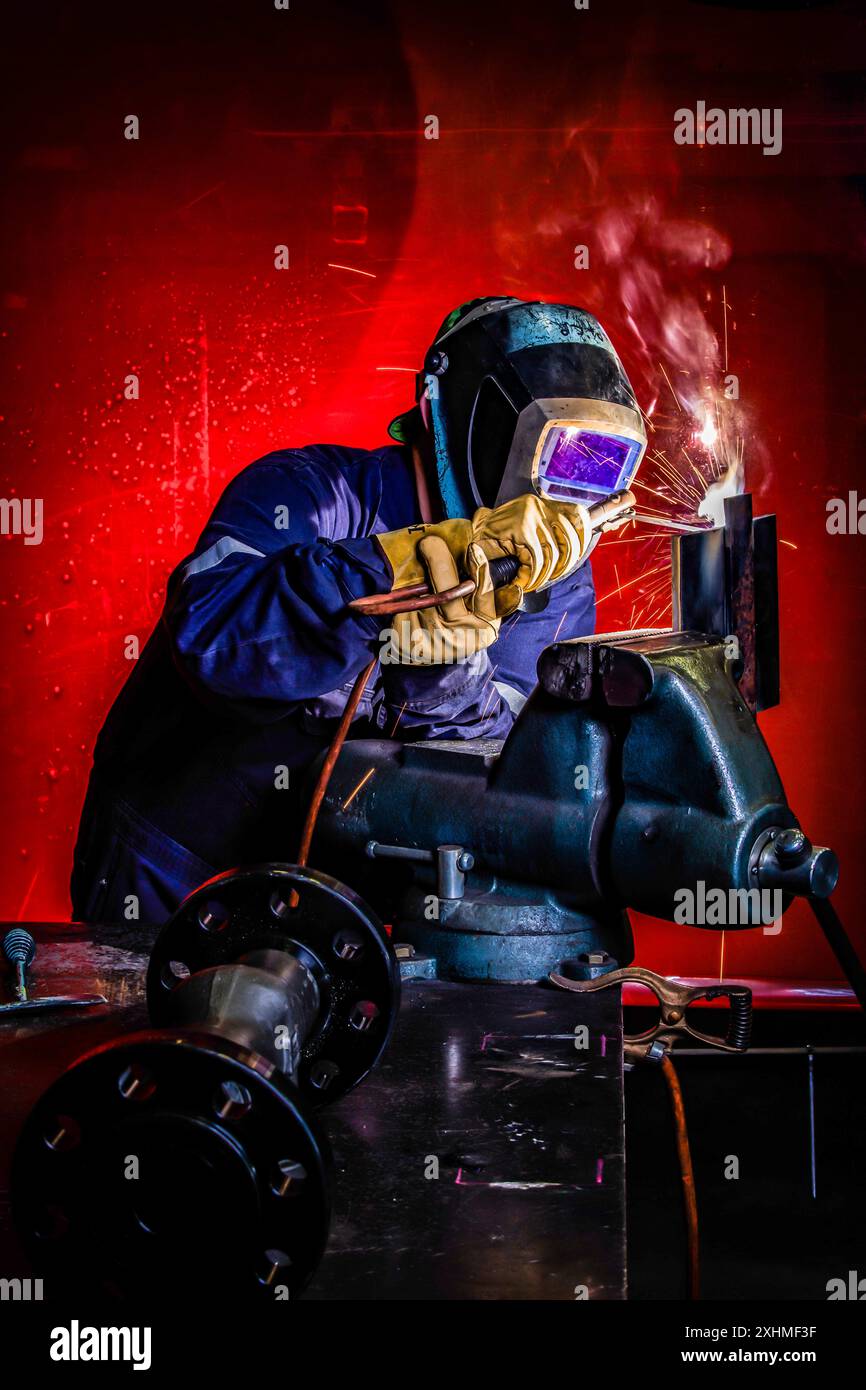 Welding in heavy machine shop Stock Photo