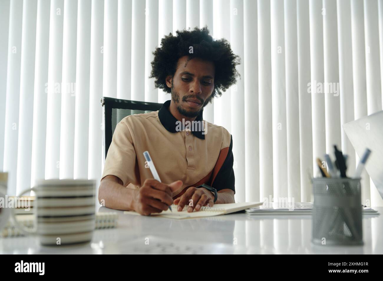 Businessman Making Notes At Meeting Stock Photo