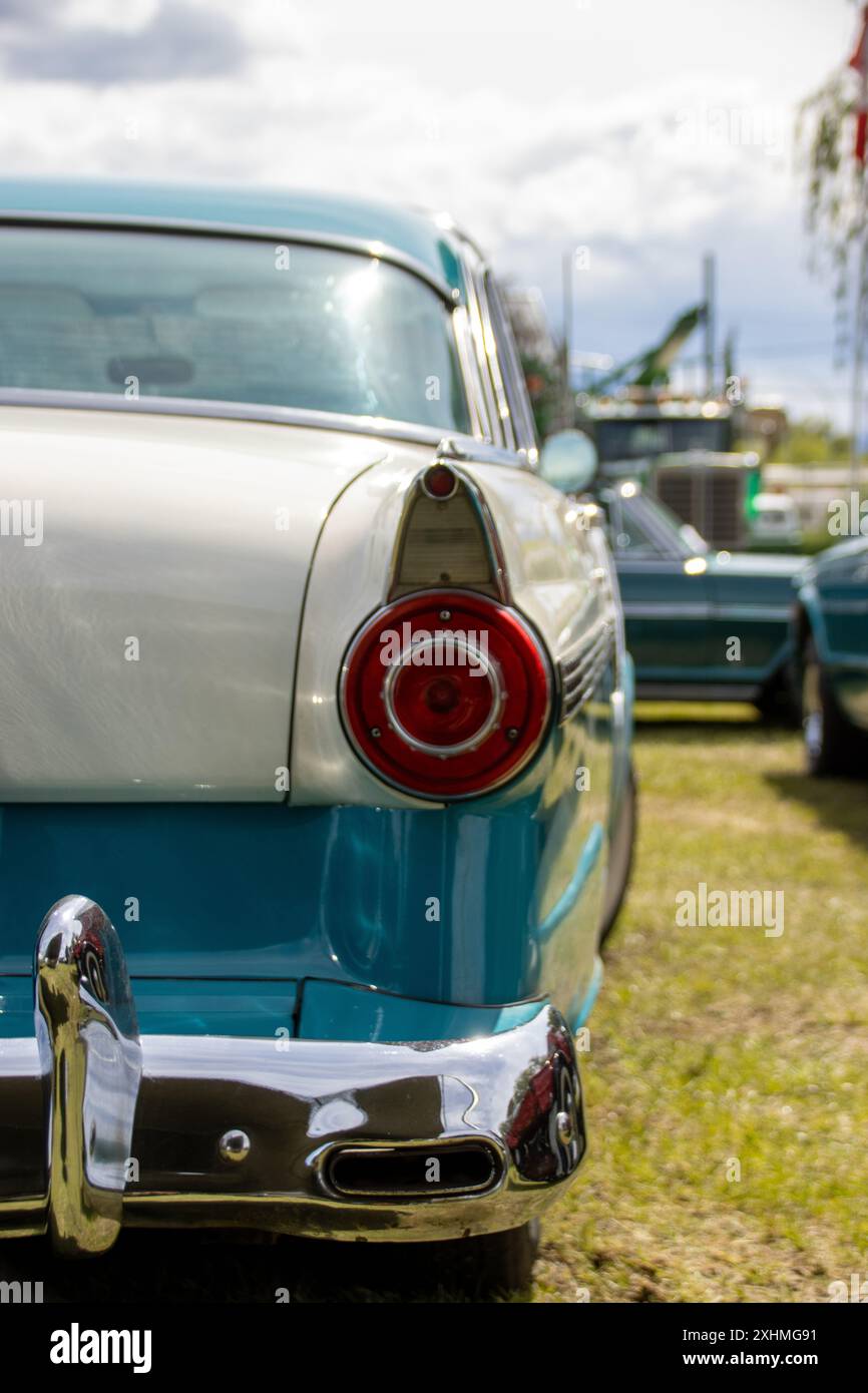 Close-up of a vintage car's tail light and fin at an outdoor show Stock Photo