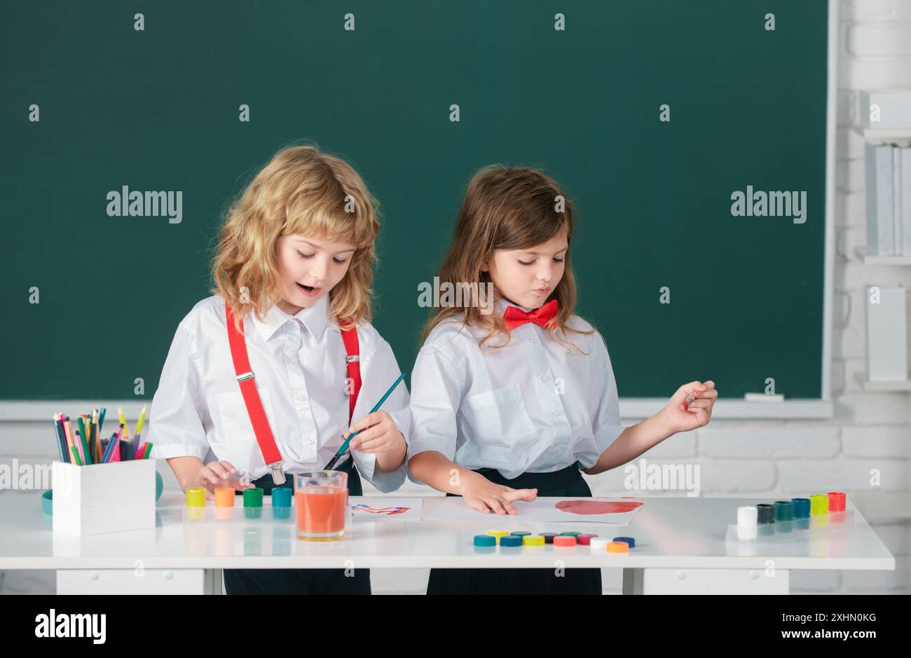 School children drawing a colorful pictures with pencil crayons in ...