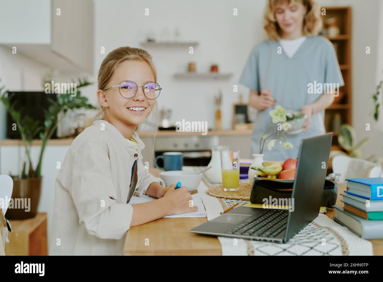 Portrait of student Caucasian girl sitting at dining table and smiling ...