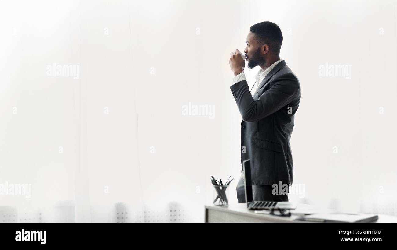 Businessman Drinking Coffee by Window Stock Photo