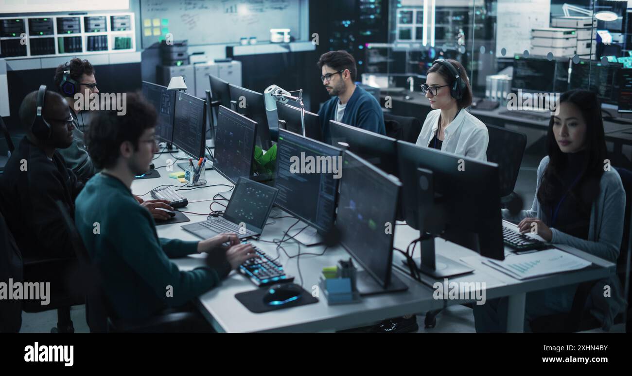 Team of Six Diverse Multiethnic Software Developers Working on Computers, Programming Advanced Code, Managing Artificial Intelligence Projects Online for Innovative Internet Based Blockchain Stock Photo