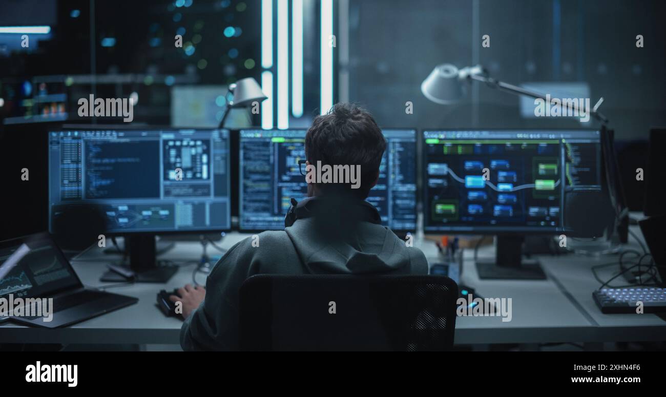 Developer using multiple displays coding hi-res stock photography and ...