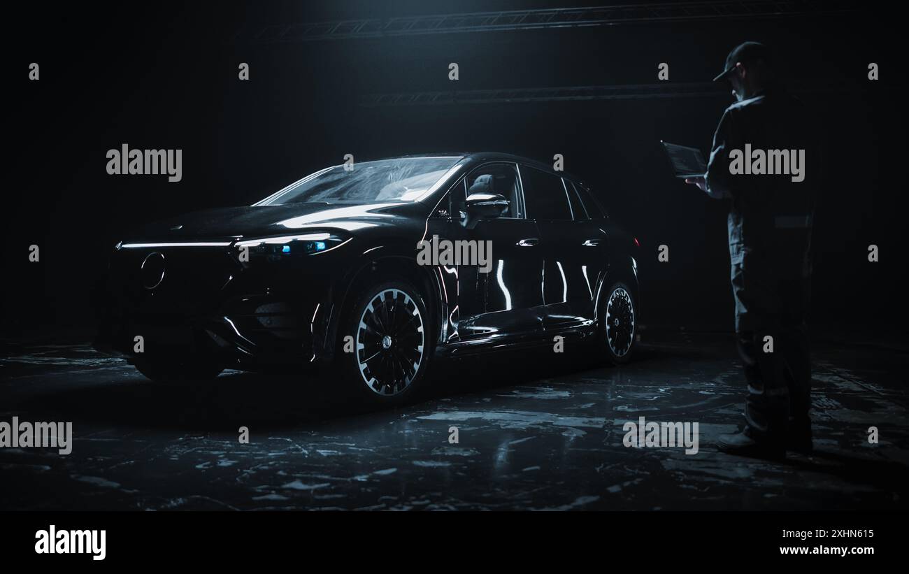 Car Manufacturing Engineer Using Laptop Computer, Programming a Brand ...