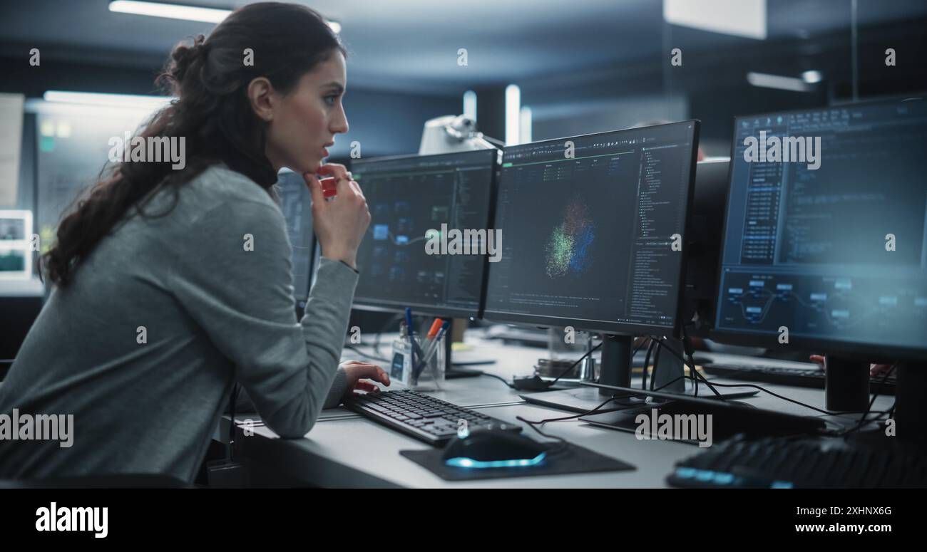 Portrait of a Thoughtful Young Engineer Working on Computer in a Technological Office Environment. Beautiful Multiethnic Woman Writing Software Code for a Blockchain Project Stock Photo