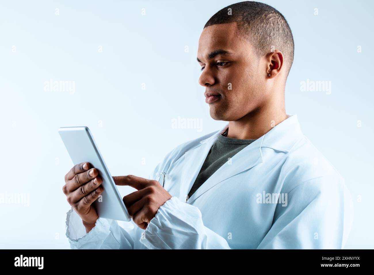 Man in a white lab coat, using a digital tablet, focuses on deep ...