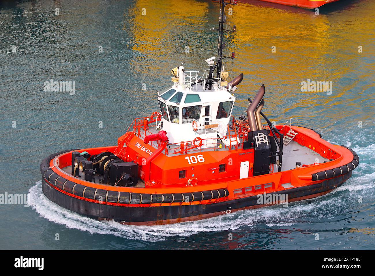 Harbour tug “Malta” returns to its mooring after another busy day towing and manouvring large vessels in and out of the Italian port of Genoa. Stock Photo