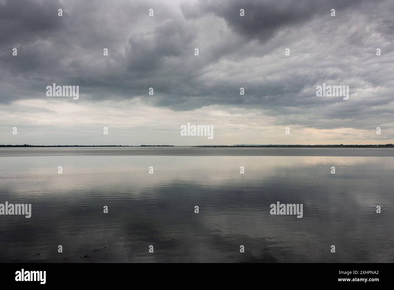 Dramatic stormy dark cloudy sky over sea Stock Photo