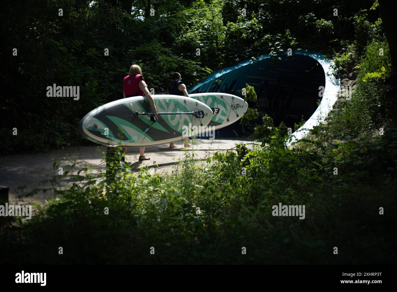 Carrying paddle boards into a tunnel Stock Photo