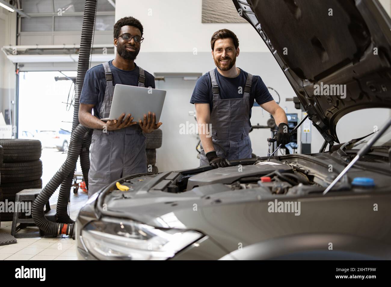 Two mechanics working on car engine in garage Stock Photo - Alamy