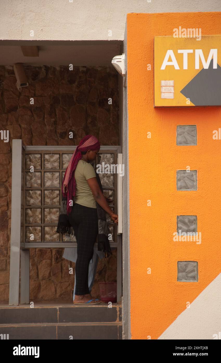 Young woman using ATM, Kaduna, Kaduna State, Nigeria, Africa. modern activity; modern dress; head-scarf Stock Photo