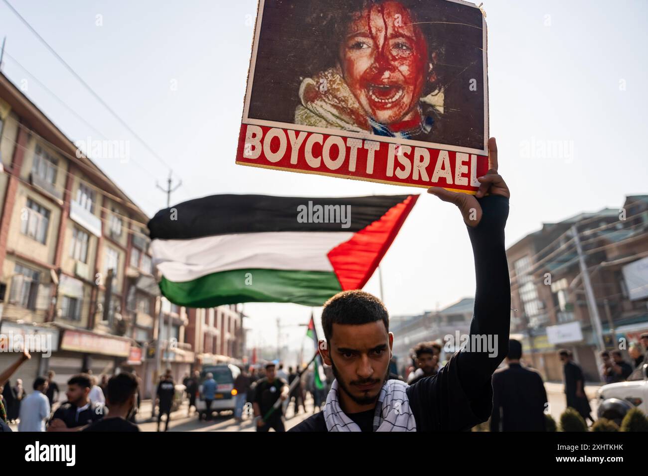A Kashmiri Shia Muslim boy holds a placard that says "Boycott Israel ...