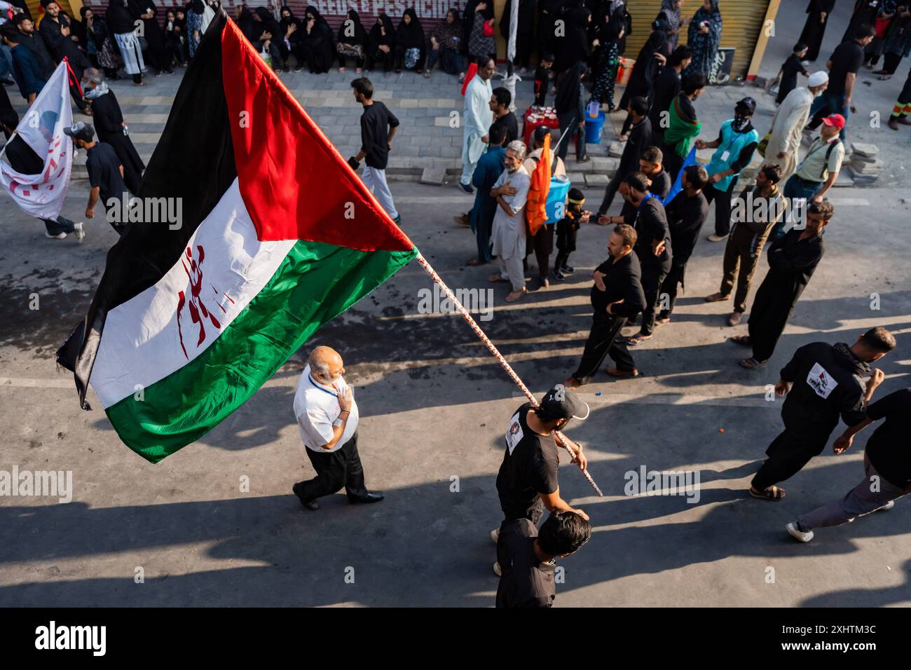 A Kashmiri Shia Muslim man walks with a Palestinian flag inscribed with ...