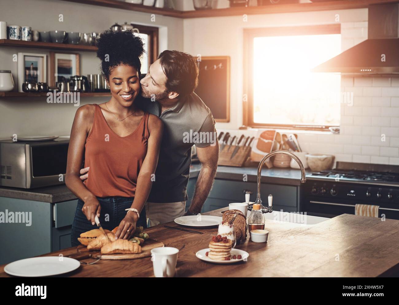 Happy, couple and kiss in kitchen with breakfast for morning affection ...