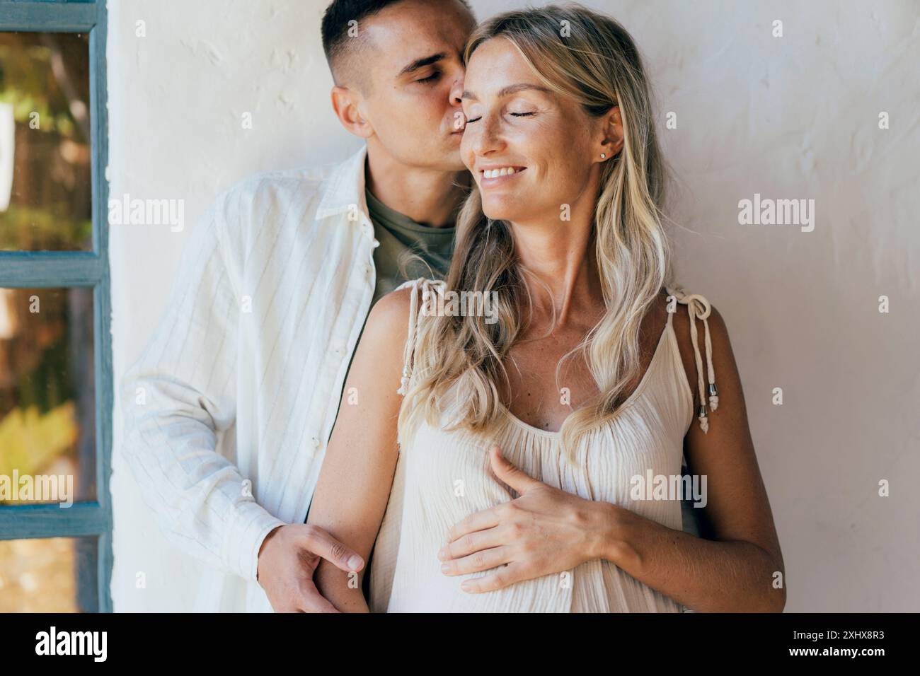 A man hugs and kisses his smiling happy pregnant wife Stock Photo - Alamy