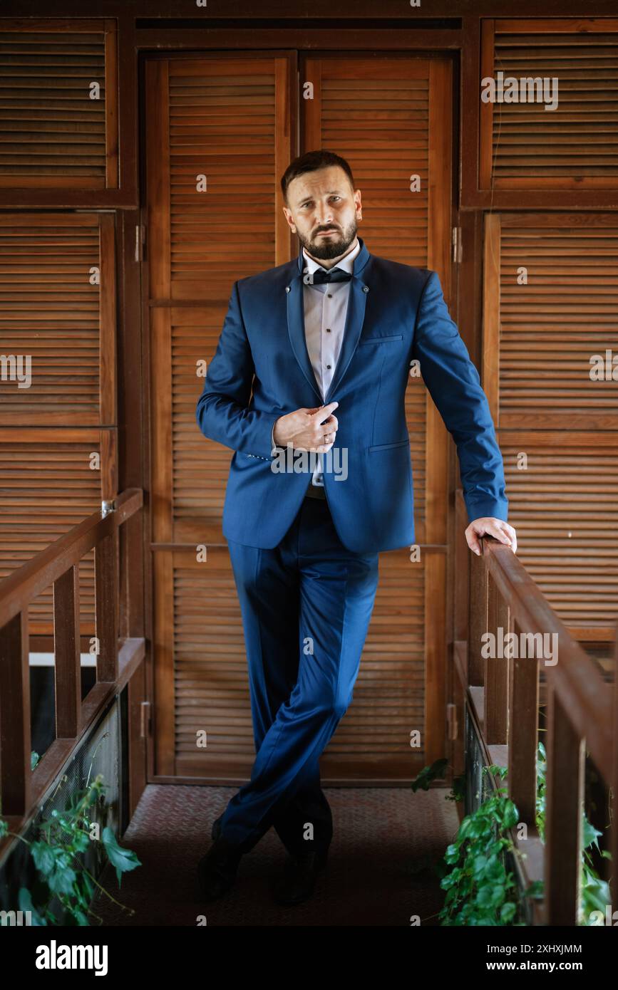 portrait of a groom with a beard in a blue suit and bow tie Stock Photo ...