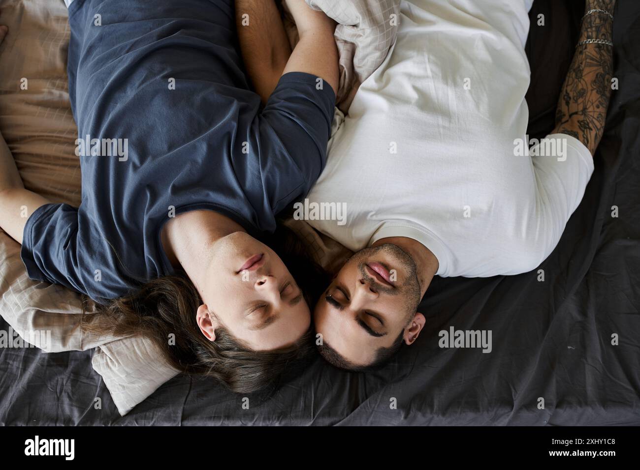 Two Young Men Are Lying In Bed Together Asleep And Holding Each Other