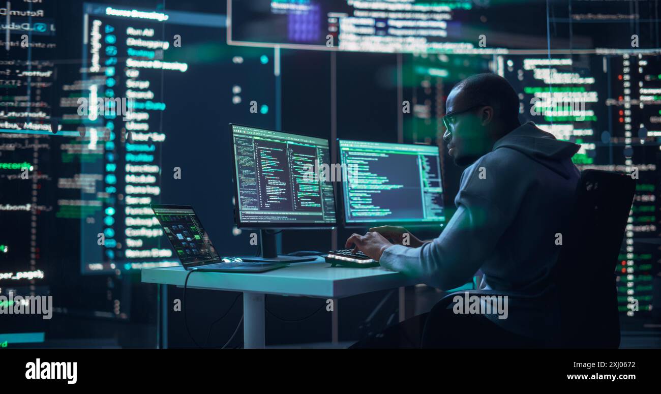 Black Male Developer Typing on Computer, Surrounded by Transparent Screens Showing Code Prompts. Professional Programmer Creating Complex Software, Running Coding Tests. Futuristic Programming Concept Stock Photo