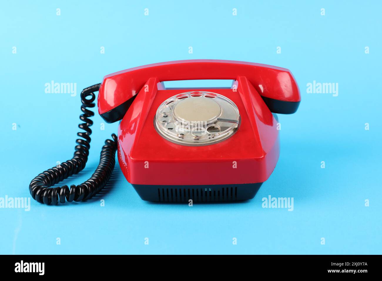 Red telephone with handset on light blue background Stock Photo - Alamy