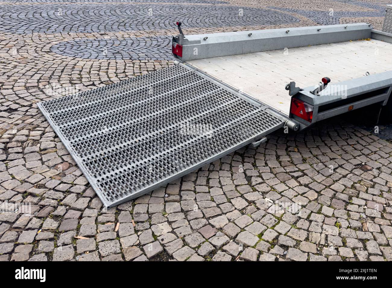 An auto trailer is depicted with its ramp fully lowered, prepared for ...