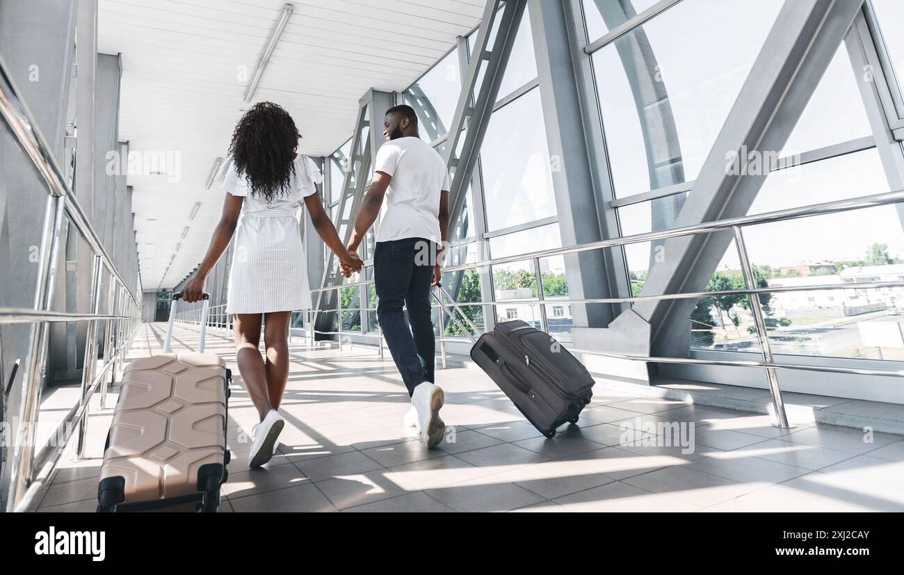 Back View of Couple Walking Through Airport Terminal With Luggage Stock ...