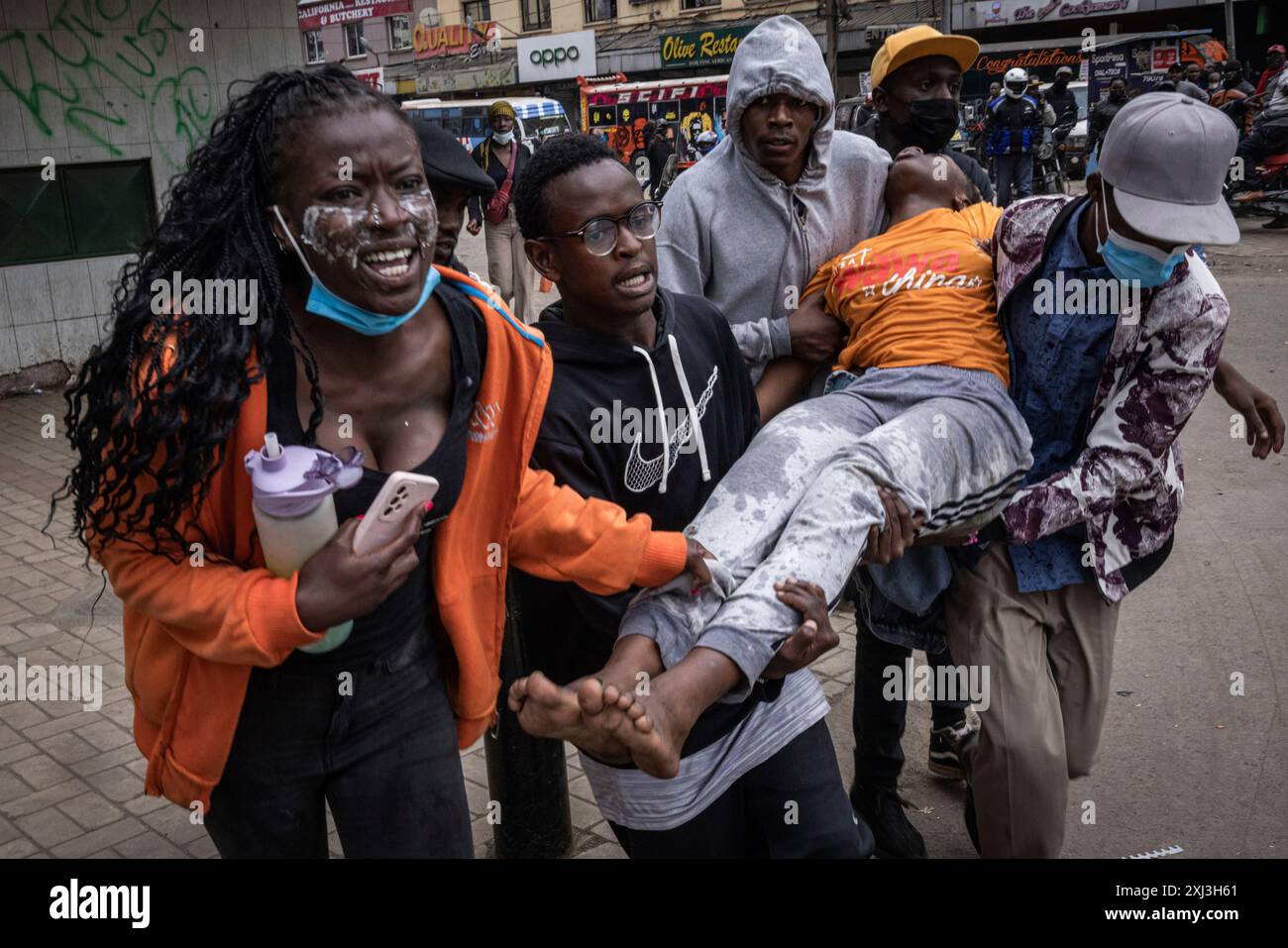 People carry an unconscious woman during a protest in Nairobi, Kenya ...