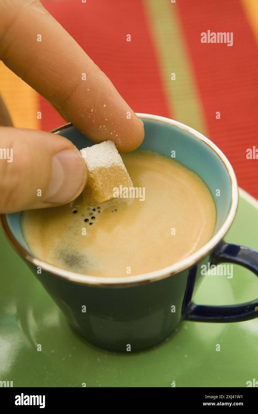 Putting a sugarlump in a cup of coffee Stock Photo - Alamy