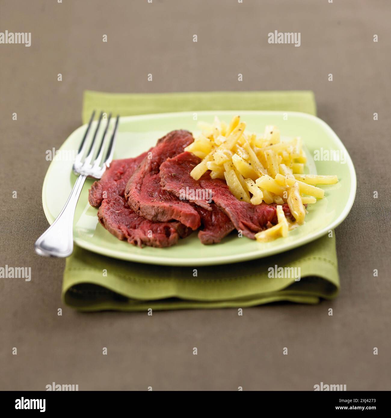 Sliced roasted venison with salsifies Stock Photo - Alamy