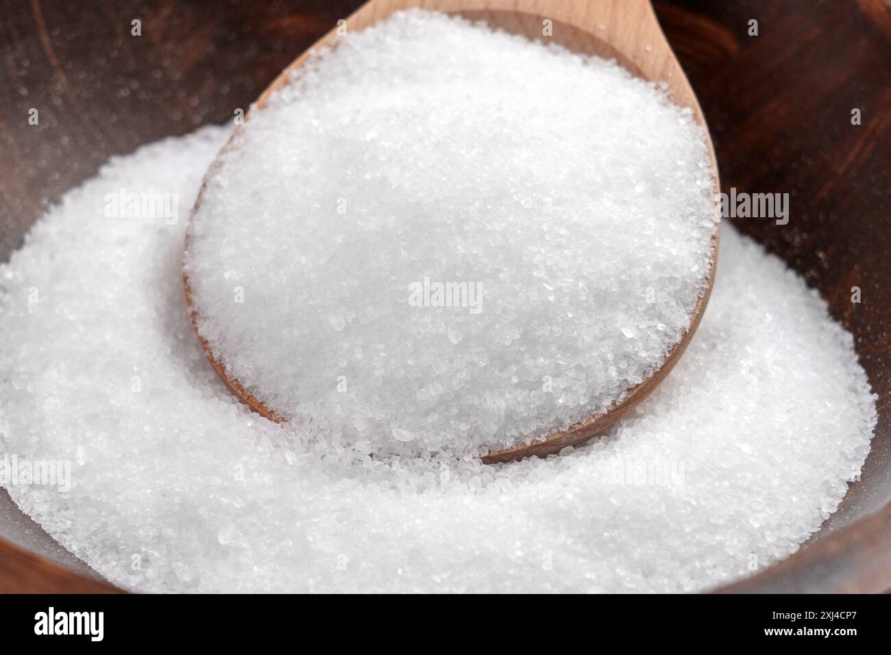 Epsom salt (Magnesium sulfate) crystals in wooden spoon close up ...