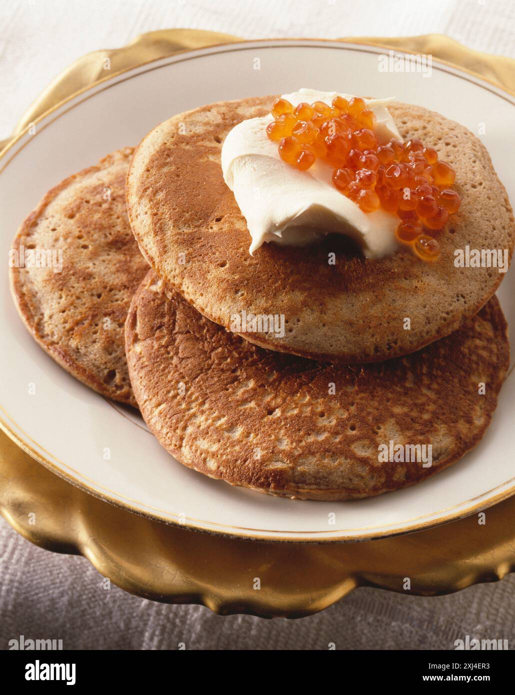 Chestnut blinis with salmon roe Stock Photo - Alamy