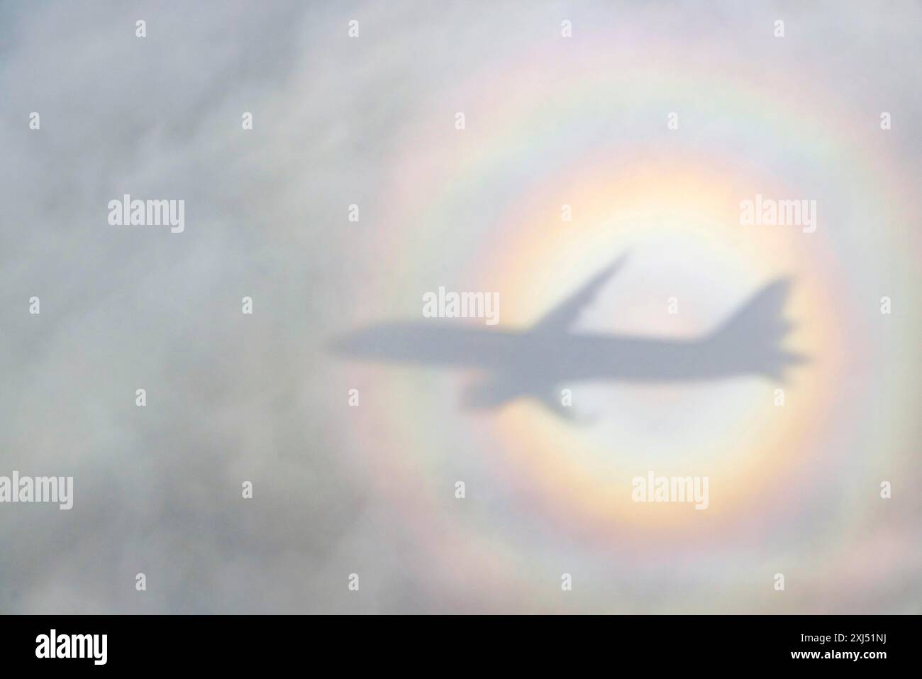 An aeroplane casts a shadow on a cloud, silhouette, halo rainbow. Germany Stock Photo