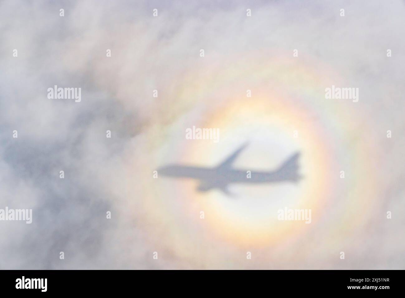 An aeroplane casts a shadow on a cloud, silhouette, halo rainbow. Germany Stock Photo