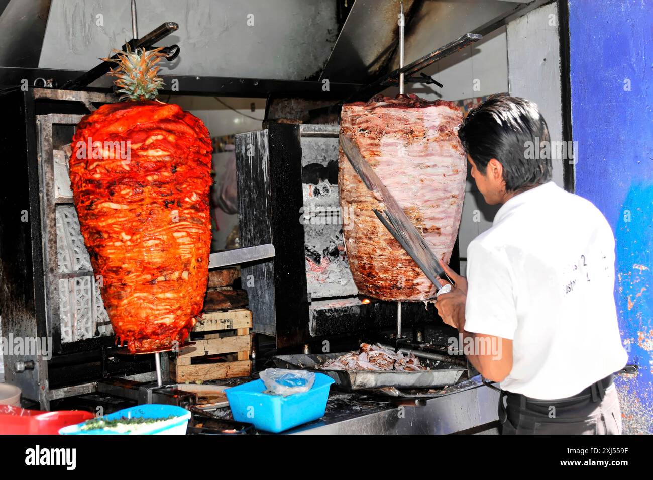 Puebla, Mexico, Central America, A man grills big trompos of meat at a street market, Oaxaca Stock Photo