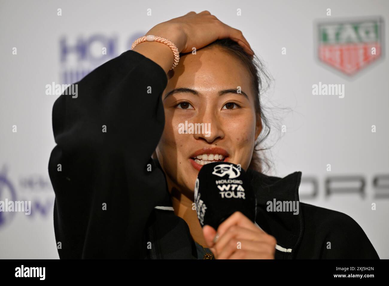 Qinwen Zheng (CHN) portrait, smiles, microphone, mike, logo, WTA, press