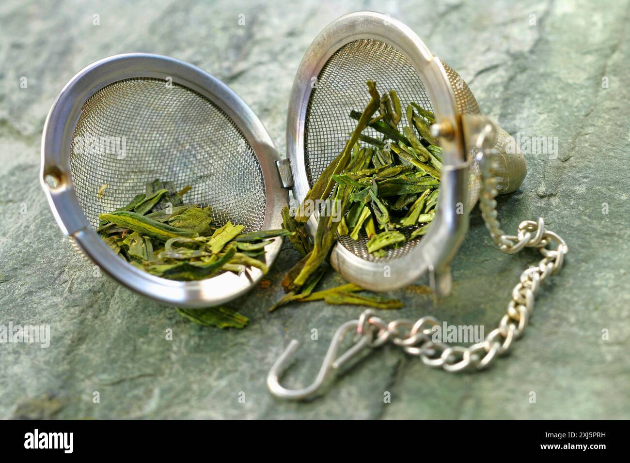 Green tea in a tea ball infuseur Stock Photo - Alamy