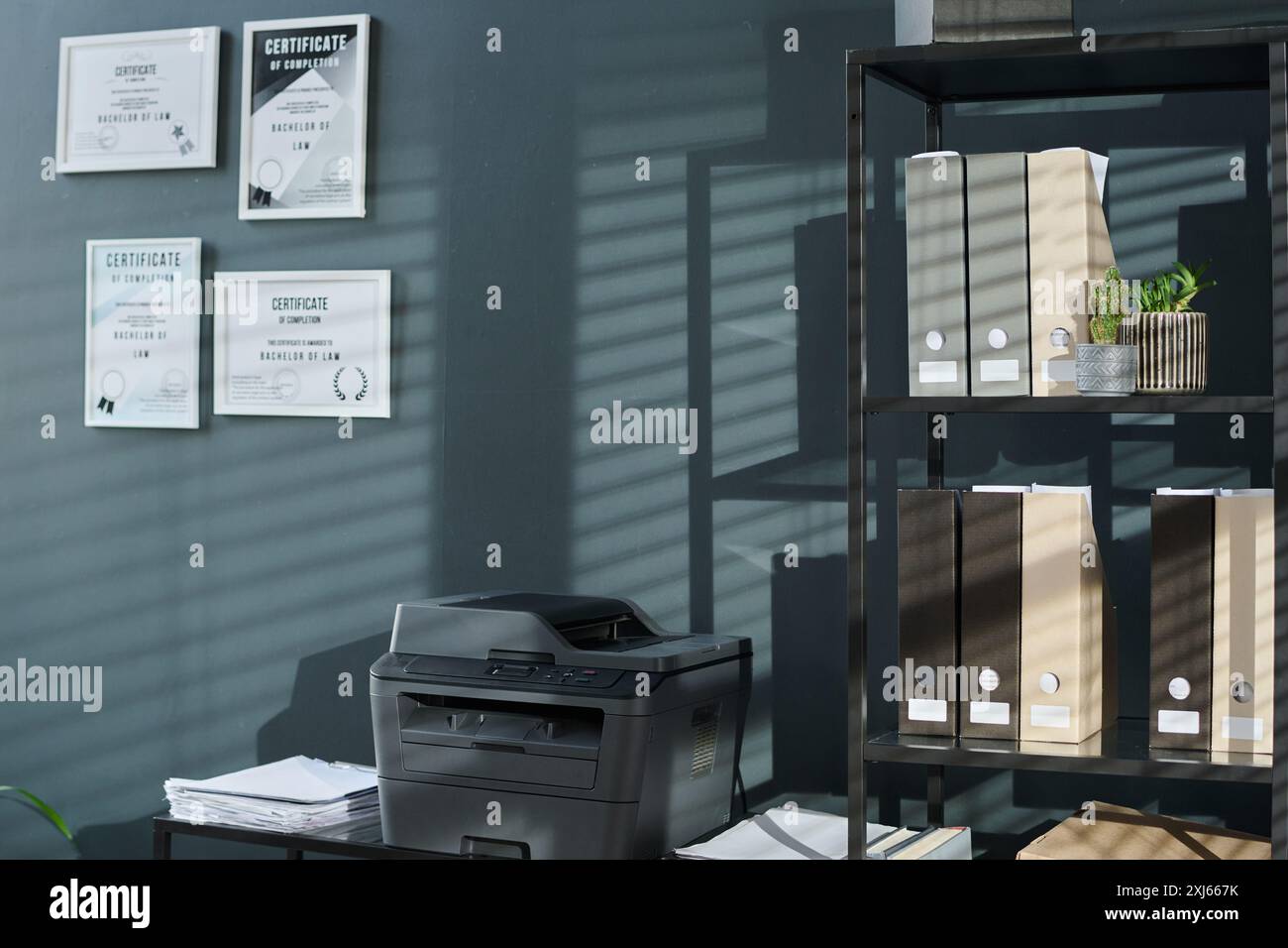Four certificates of law bachelor hanging on sunlit wall of modern ...