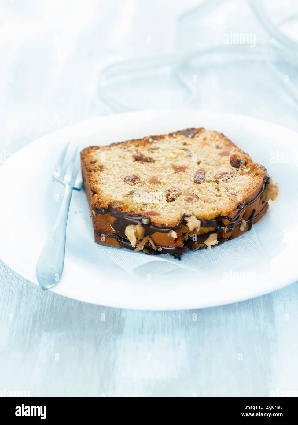 Tranche de cake aux fruits confits et sauce chocolat Stock Photo