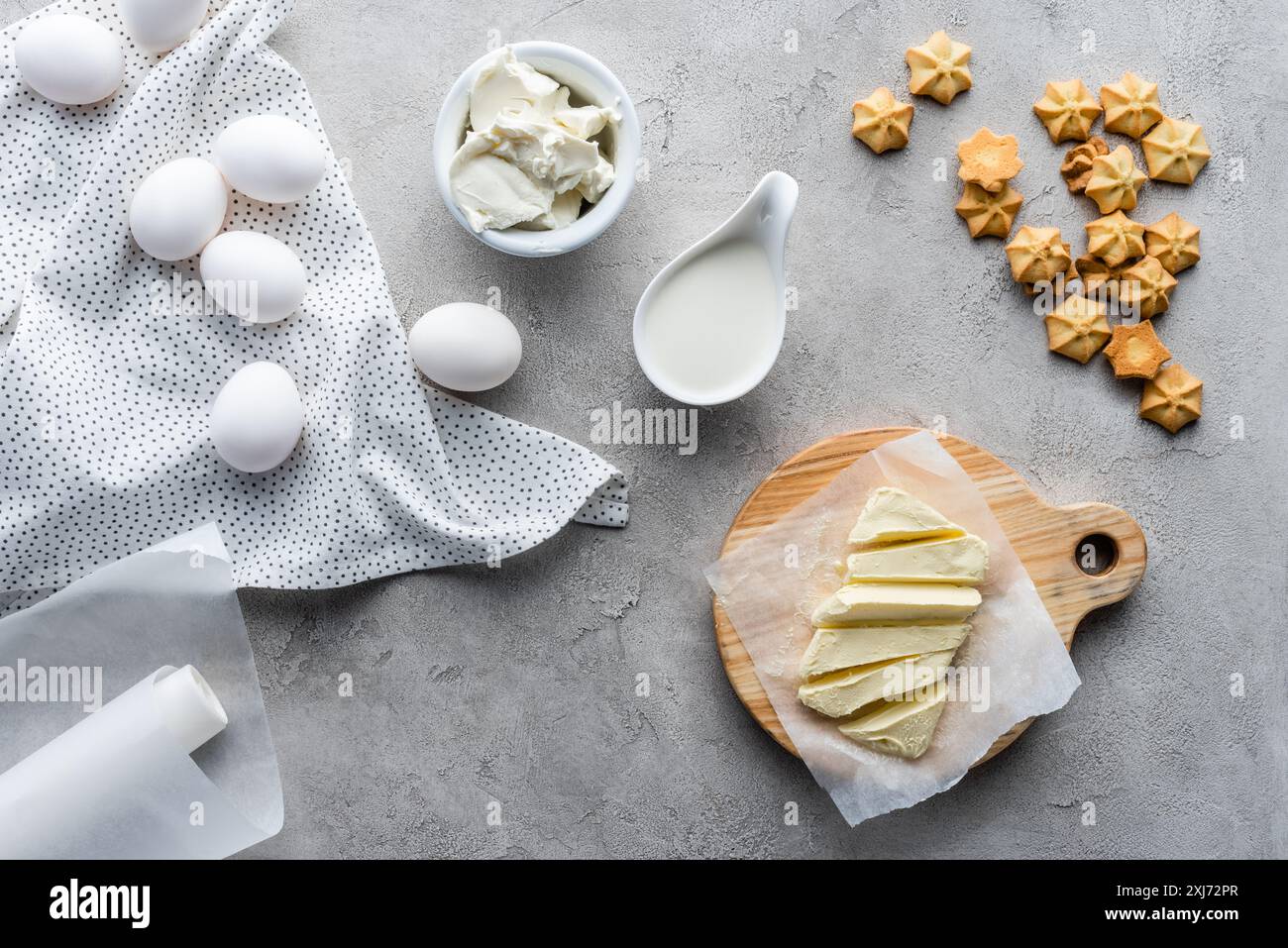 cut butter, sour cream, cookies and raw chicken eggs ingredients for making pie Stock Photo