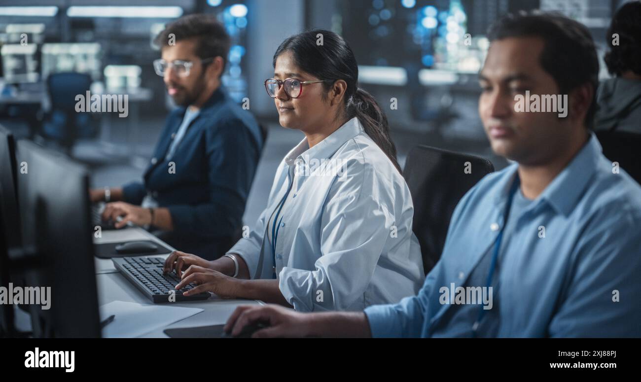 Group of Empowered Multicultural Men and Women Working in a Research Center, Using Computers to Run Advanced Software, Develop Artificial Intelligence Interface and Neural Network Blockchain Stock Photo