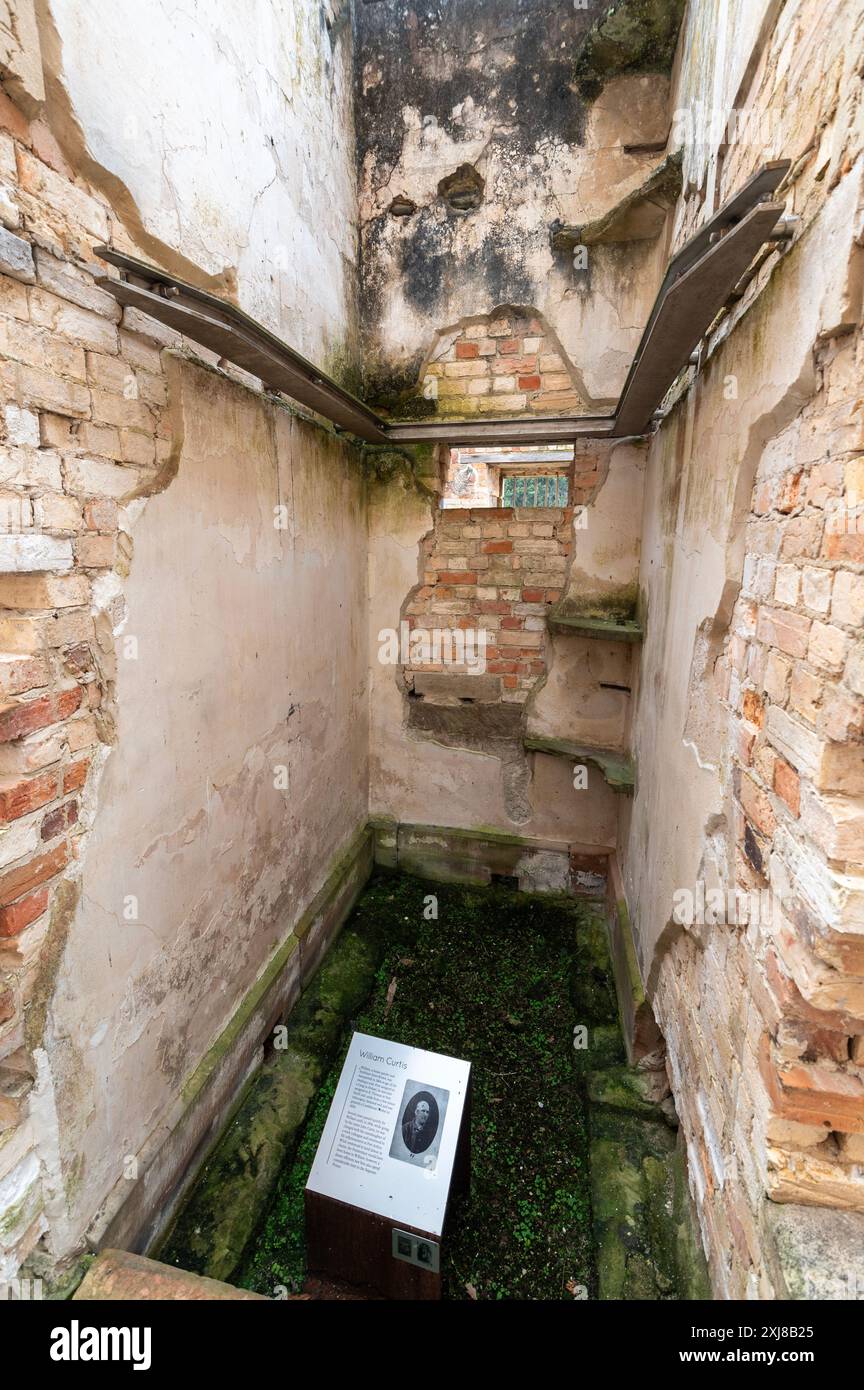 The name and conviction of one of the prisoners held in this tiny ruined narrow cell within the ruins of the Penitentiary at Port Arthur on the Stock Photo