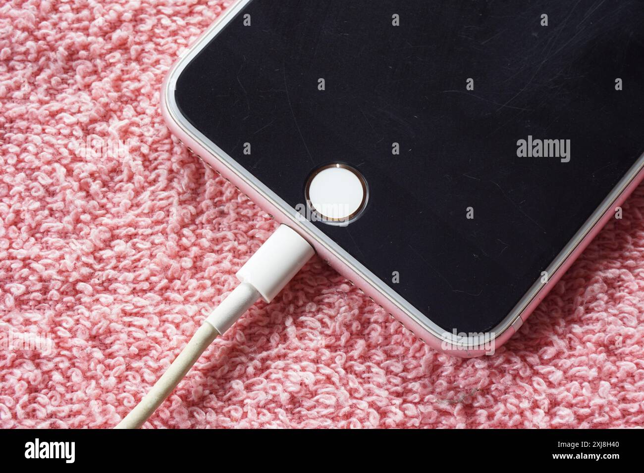 Closeup of black apple iphone is charging on red background Stock Photo