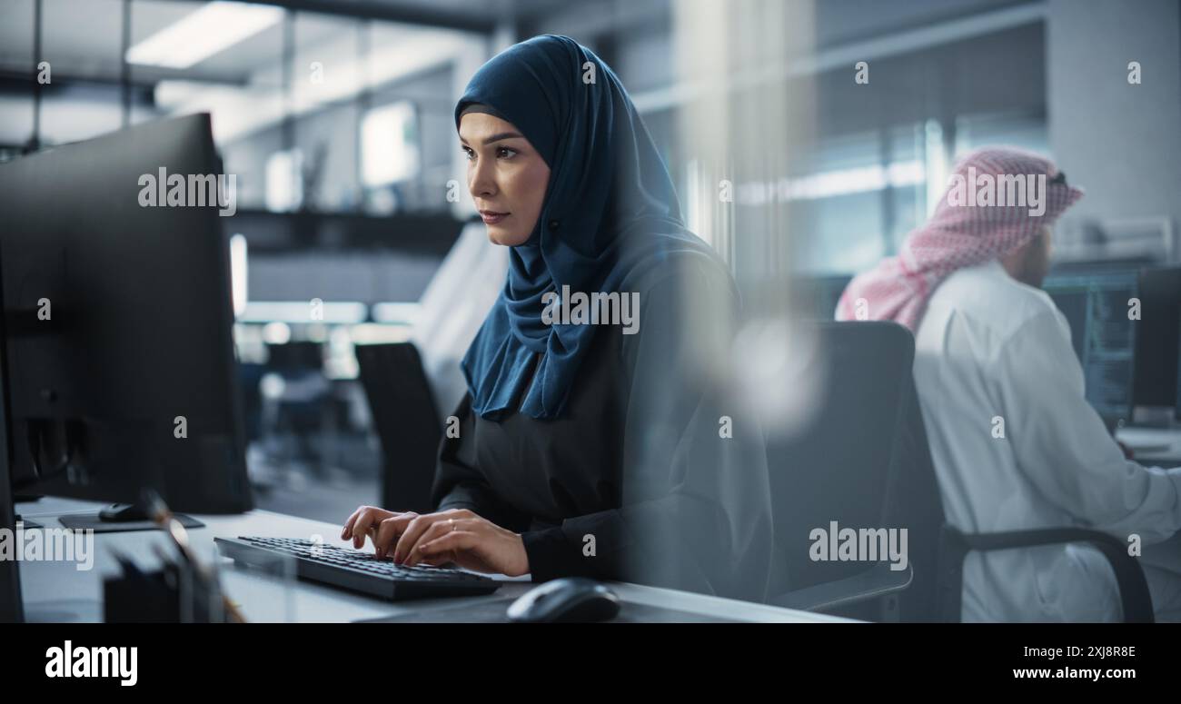 Portrait of a Smart Focused Middle Eastern Engineer Working on Computer in a Technological Corporate Office. Young Arab Woman in Hijab Developing Software for an Innovative Internet Service Provider Stock Photo