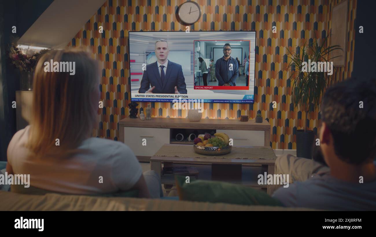 Caucasian couple watches news broadcast about US presidential elections ...