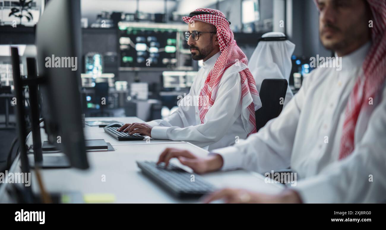 Two Young Middle Eastern Colleagues Working in a Cyber Security Software Development Department. Young Arab Manager Updating Software Developer on the Artificial Intelligence Safety Project Stock Photo